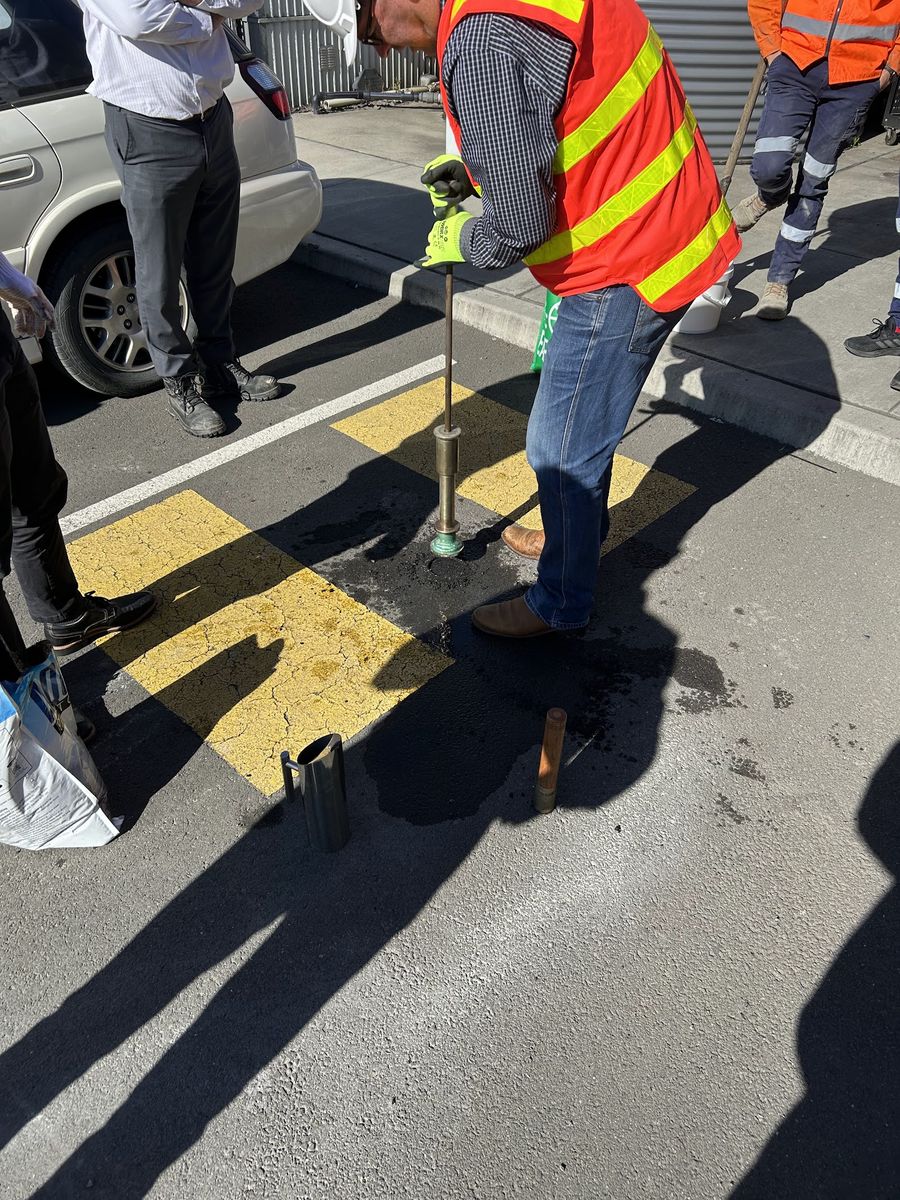 Worker applying Aqua Patch beside a curb
