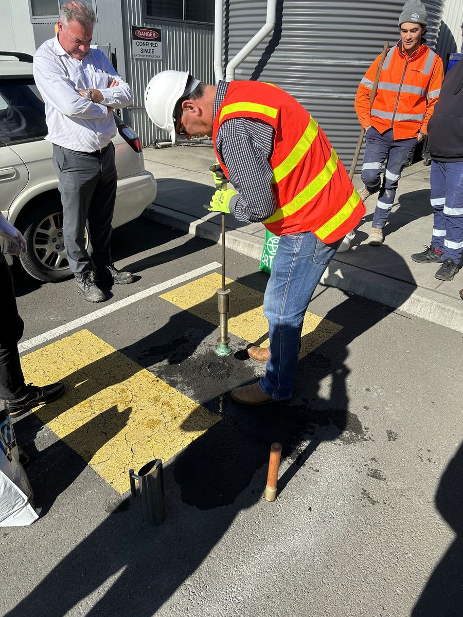 Worker compacting Aqua Patch with a tamper
