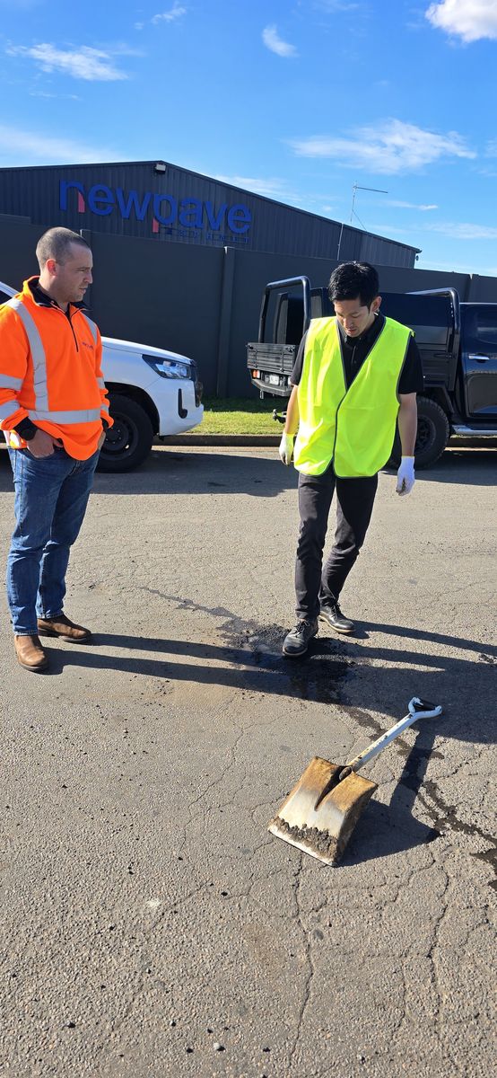 Two workers with equipment near a truck
